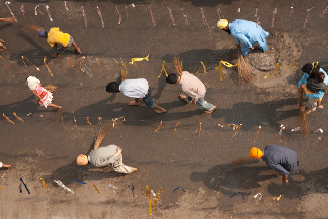_DSC1334.jpg - Sweeping the road in front of the holy book