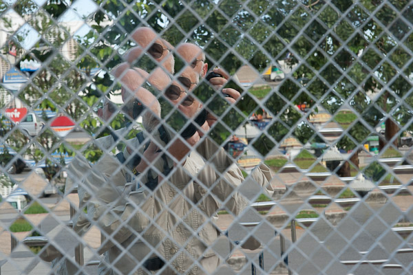 Thailand_OctNovDec_2010_Chiang_Mai_3180.jpg - Autoportrait in the mirrored wall of a temple.  The wall faced the street.  Great fun!